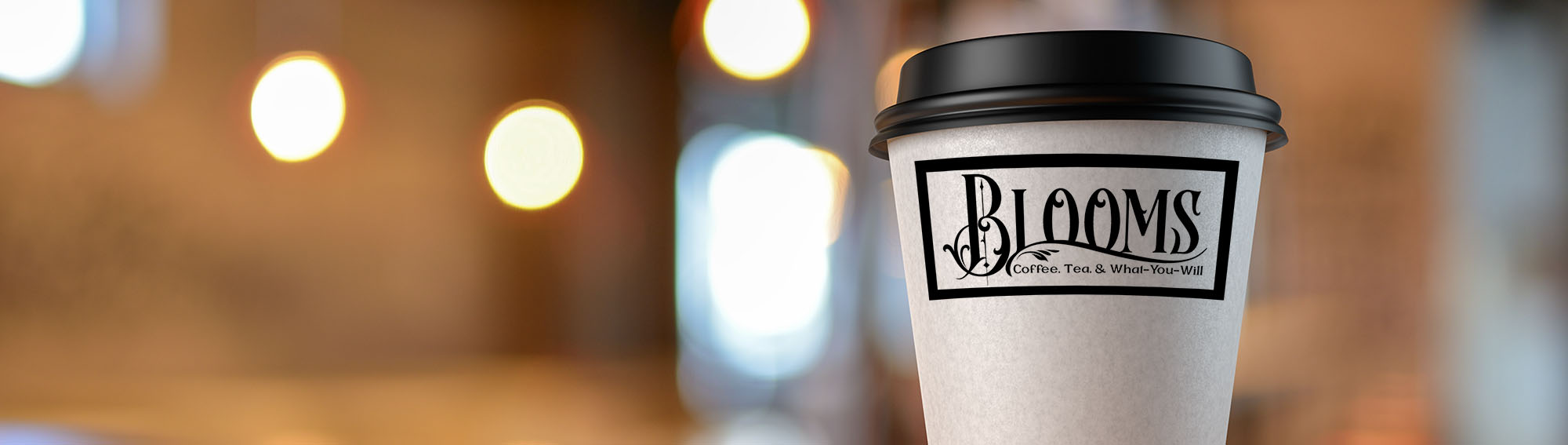 Coffee cup with the logo, 'Blooms - Coffee, Tea, and What You Will'. 